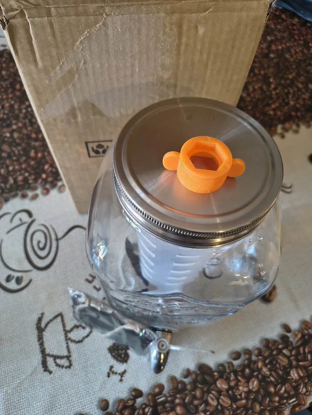 Glass Beverage Dispenser with Orange Infuser Lid and Silver Spigot
